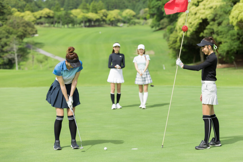 日差しの中ゴルフをする女性たち