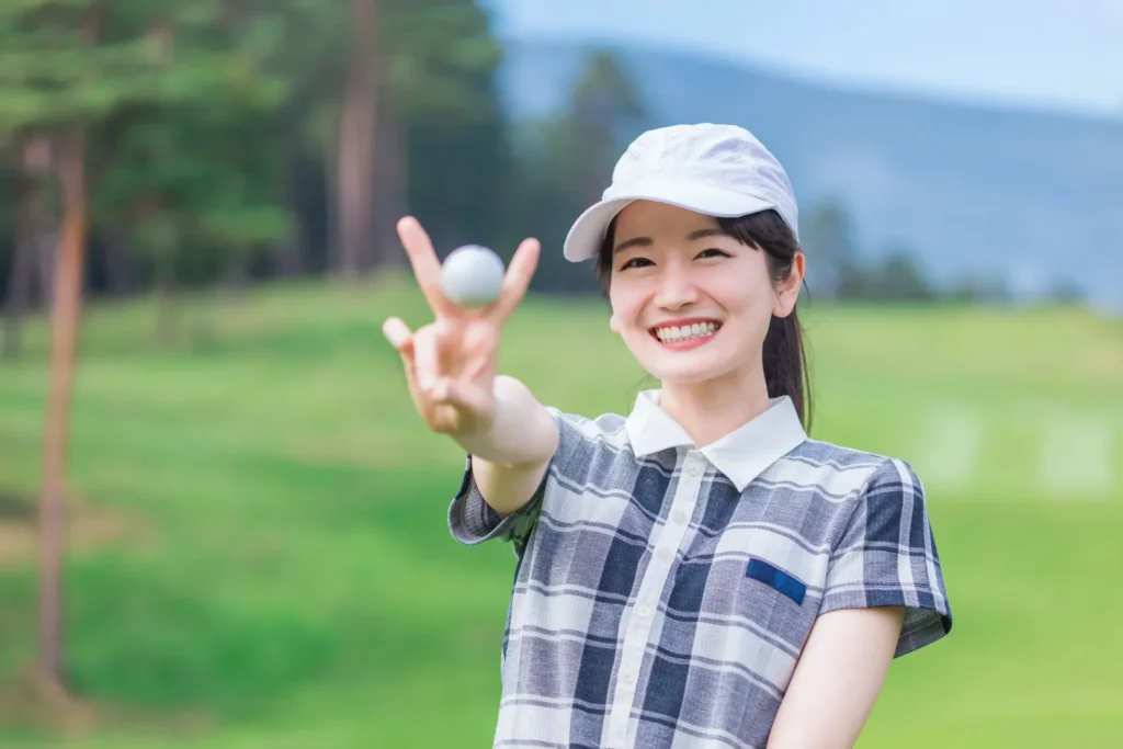ゴルフボールを持つ笑顔の女性